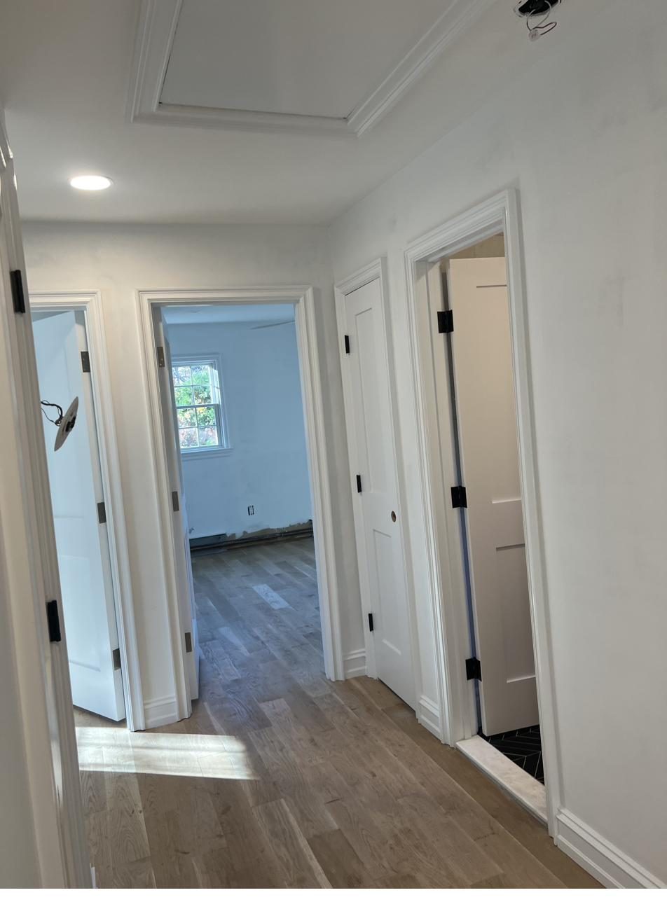 Hallway with white millwork and hardwood flooring